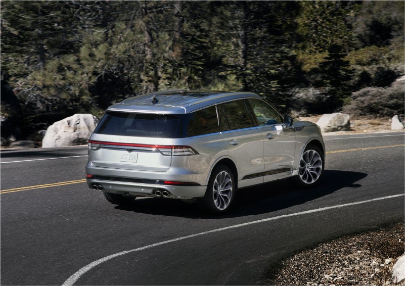 A 2023 Lincoln Aviator® Grand Touring model is shown being driven on a tight turn of a mountain road | Sheehy Lincoln of Gaithersburg in Gaithersburg MD
