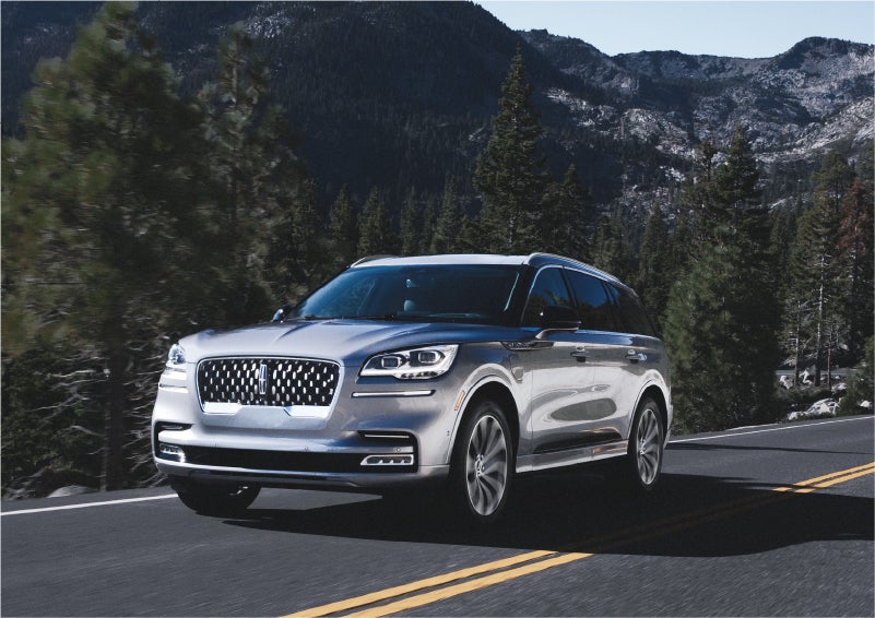 A 2023 Lincoln Aviator® Grand Touring SUV being driven on a winding road to demonstrate the capabilities of all-wheel drive | Sheehy Lincoln of Gaithersburg in Gaithersburg MD