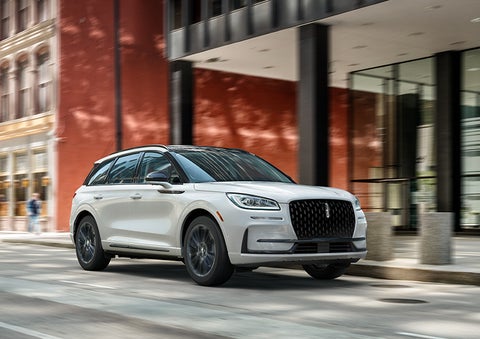 The 2024 Lincoln Corsair® SUV with the Jet Appearance Package and a Pristine White exterior is parked on a city street. | Sheehy Lincoln of Gaithersburg in Gaithersburg MD