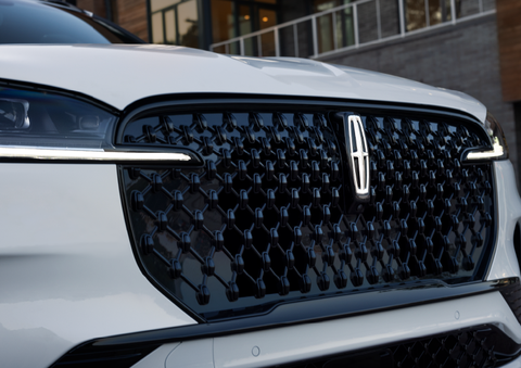 The black grille of a white 2025 Lincoln Aviator® SUV is shown with its fog lights on. | Sheehy Lincoln of Gaithersburg in Gaithersburg MD