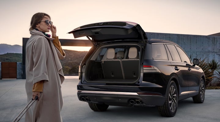 A woman approaches a 2026 Lincoln Aviator® SUV with its rear liftgate open. | Sheehy Lincoln of Gaithersburg in Gaithersburg MD