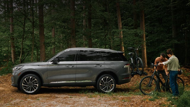 A father and son load e-bikes on a bike rack attached to a 2027 Lincoln Aviator® SUV. | Sheehy Lincoln of Gaithersburg in Gaithersburg MD