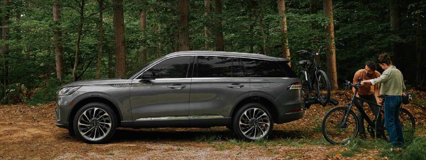 A father and son load e-bikes on a bike rack attached to a 2027 Lincoln Aviator® SUV. | Sheehy Lincoln of Gaithersburg in Gaithersburg MD